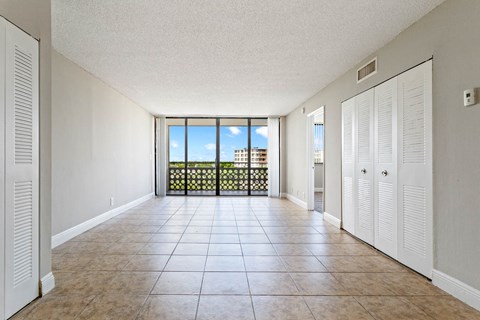 an empty living room with a balcony and a tiled floor at Fairways of Inverrary, Lauderhill, 33319