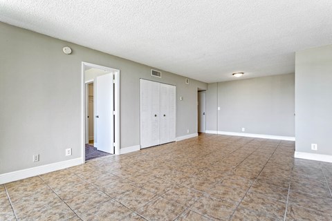 an empty living room with a tile floor and white walls at Fairways of Inverrary, Lauderhill, FL