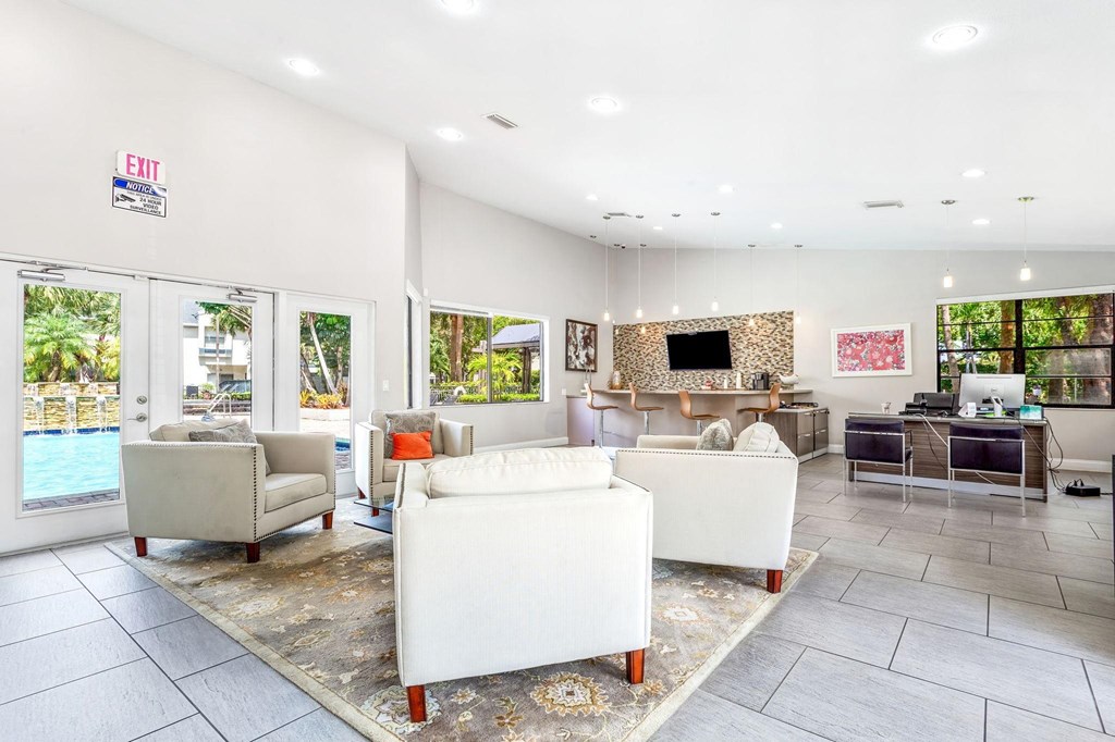 a living room with couches and chairs and a pool at Waterford Park Apartment Homes, LLC, Lauderhill