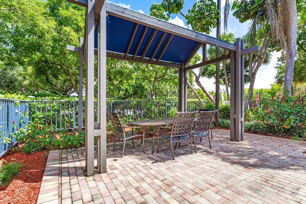 a patio with a picnic table and a pergola at Waterford Park Apartment Homes, LLC, Lauderhill, 33319