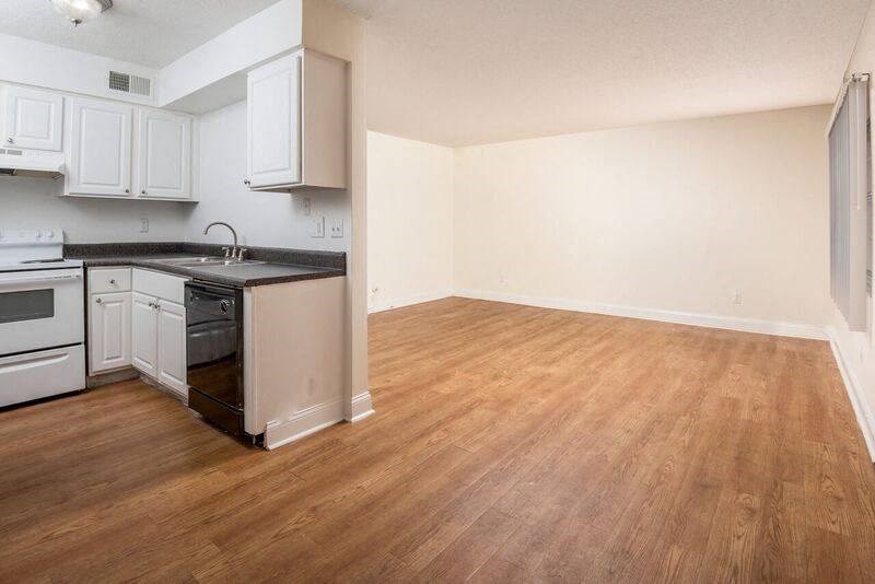 An Open concept kitchen with white cabinets and a warm toned wood floor  at Oak Manor Apartment Homes, Tampa, Florida