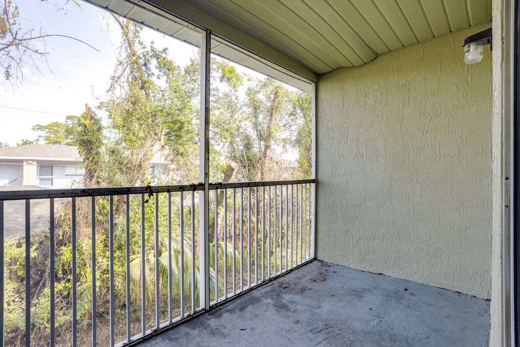 A patio with a metal railing and a view of a residential area.