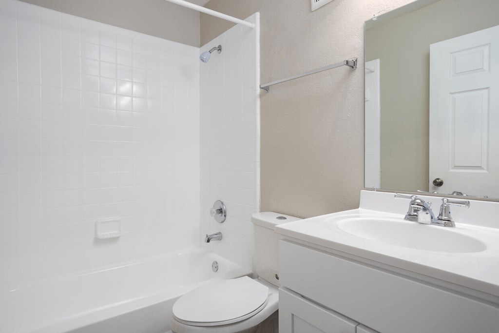A white toilet sits next to a white sink in a bathroom.