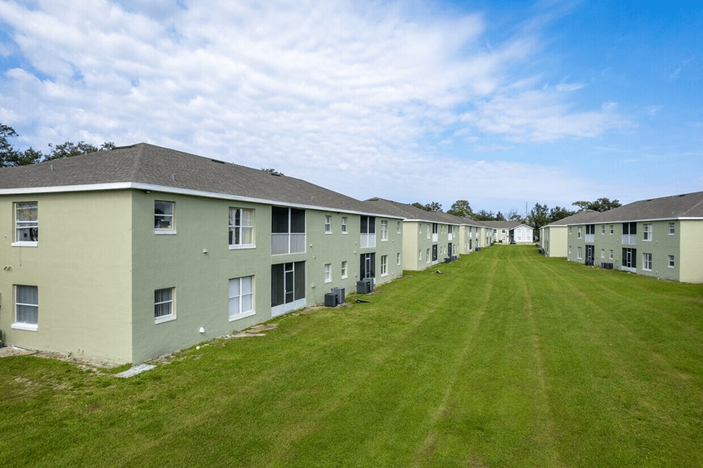 A long row of identical houses with green lawns.