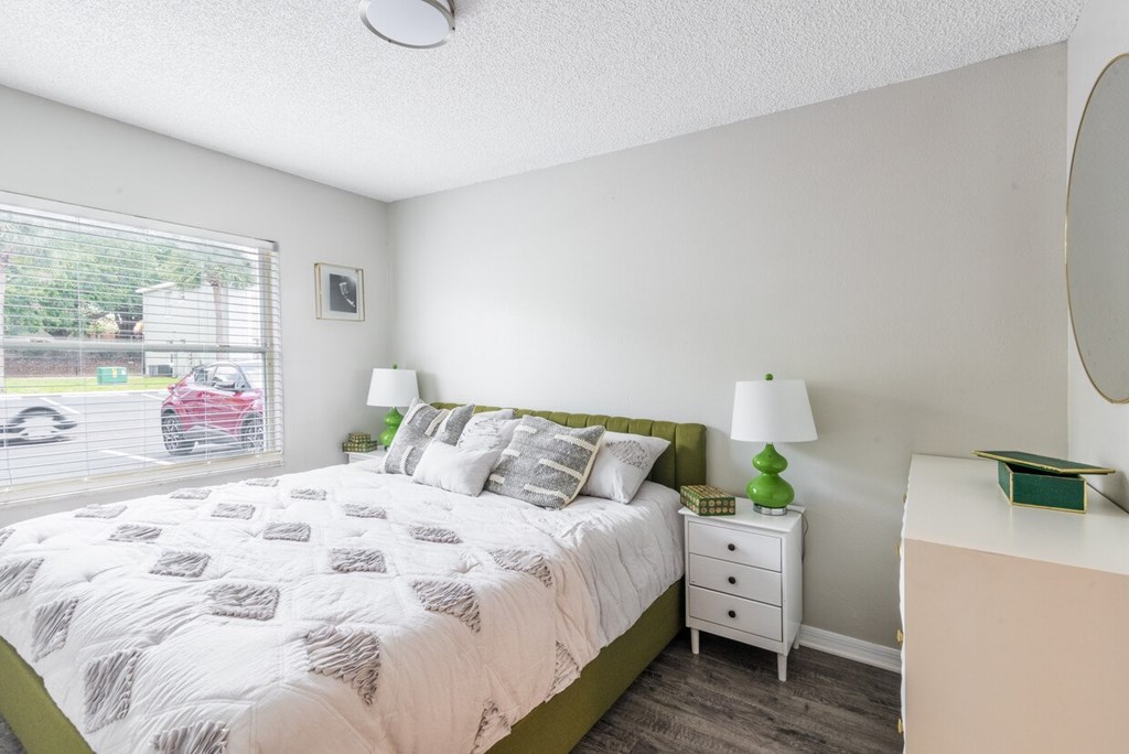 A bedroom with a bed, nightstand, and lamp.