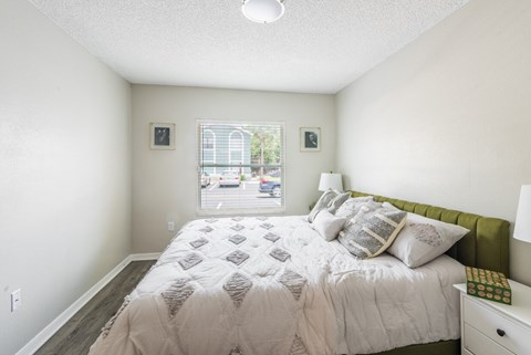 A bedroom with a large bed and a window overlooking a street.