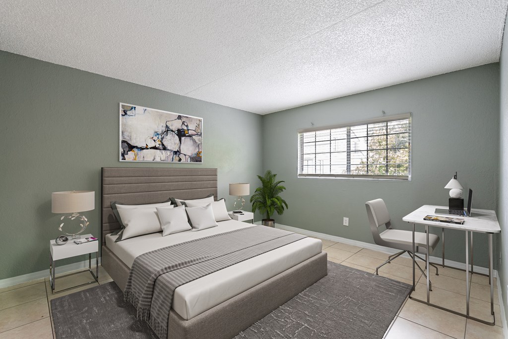 A bedroom with a large bed, a desk, and a chair.