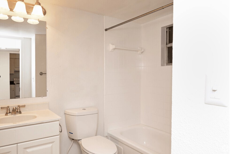 A bathroom with charming white tilework and a window for natural light.