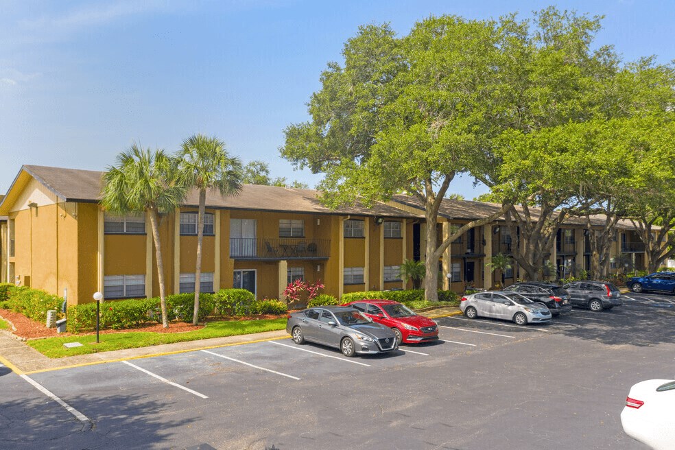 A parking lot with cars and a building in the background.