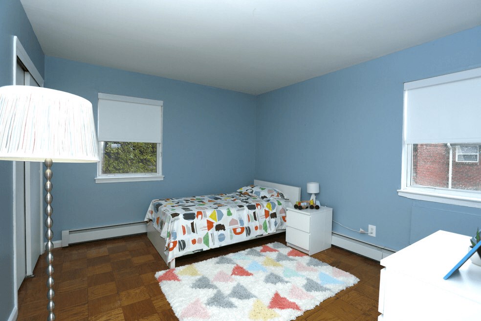 A bedroom with a bed, nightstand, and lamp.