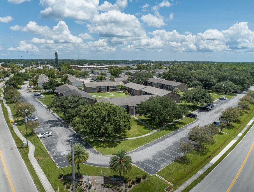 A large building complex with a parking lot in front.