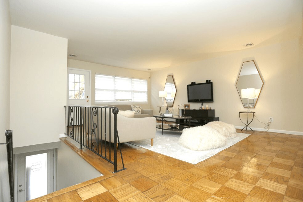A living room with a white couch and a television.