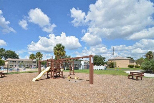 A playground with a slide and a swing set.