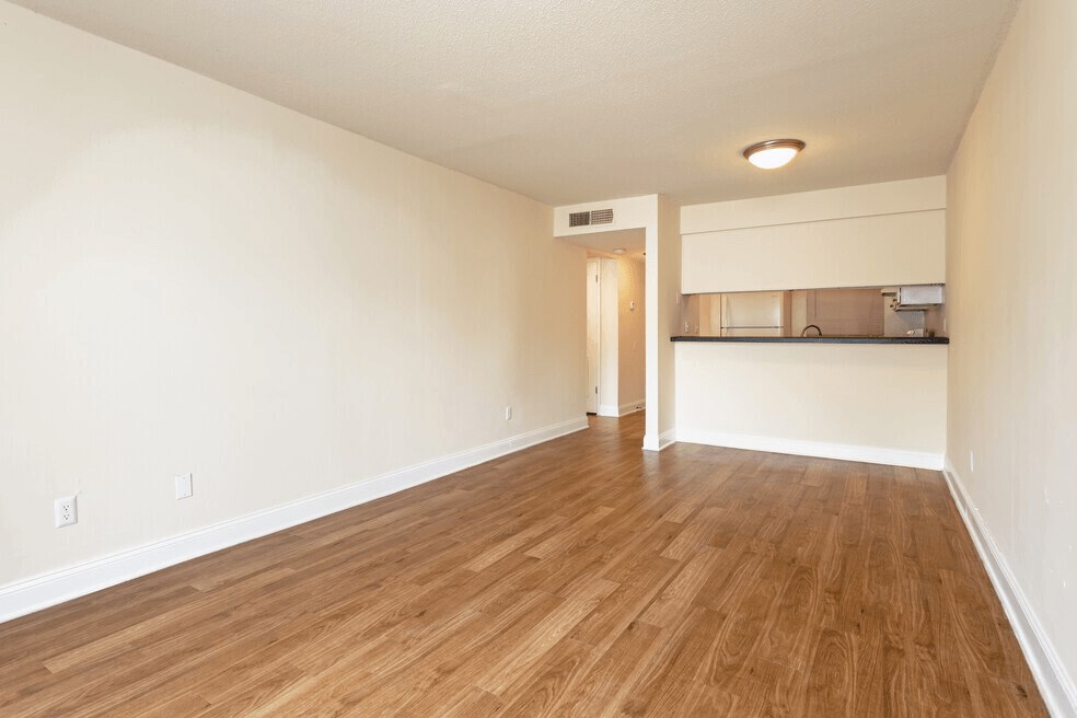 A room with warmed toned wooden flooring and trendy beige wallswalls.