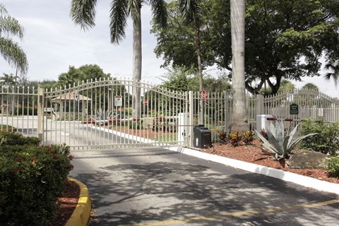 A gated entrance with a sign and a mailbox.