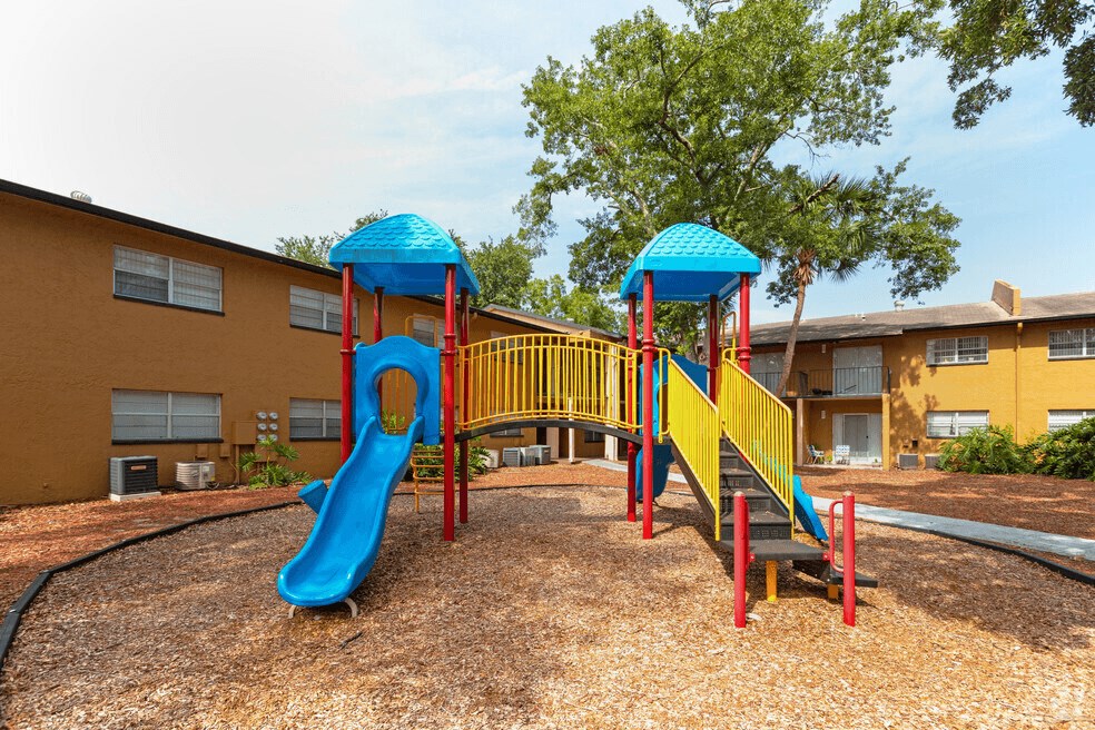 A playground with a blue slide and a yellow and red structure.