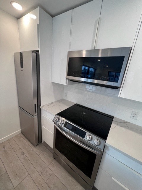 a kitchen with a stove a refrigerator and a microwave
