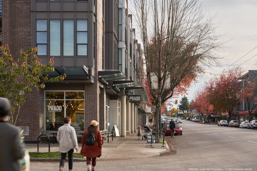 people walking down the street in front of a building