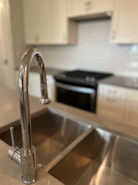 A kitchen sink with a chrome faucet.