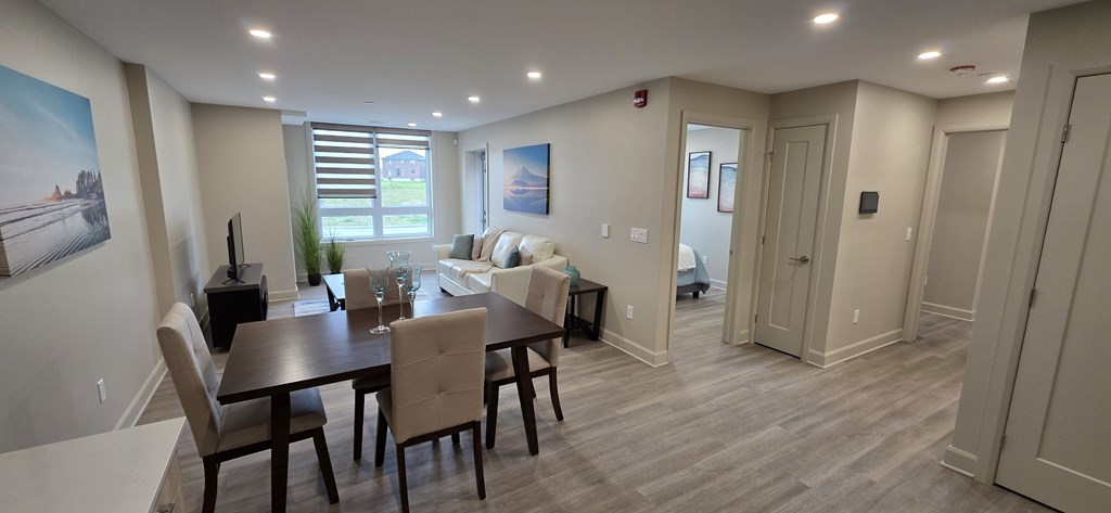 A dining room with a wooden table and chairs.