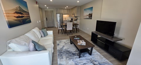A living room with a white couch and a television.