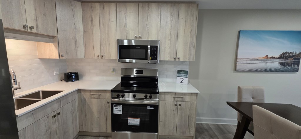A kitchen with a stove top oven and microwave above it.