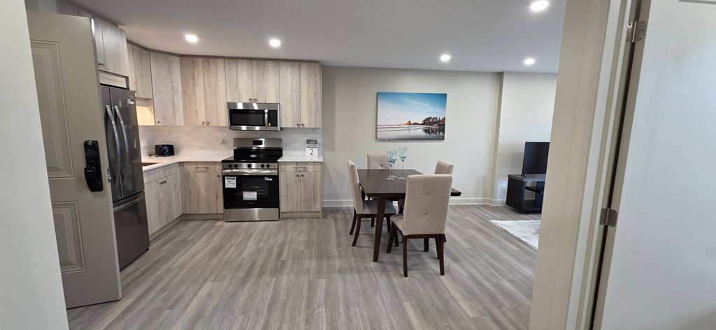 A kitchen with a dining table and chairs.