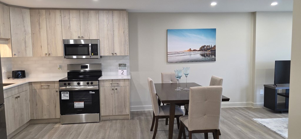A kitchen with a dining table and chairs.