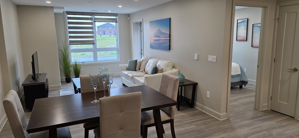 A modern dining room with a wooden table and chairs.
