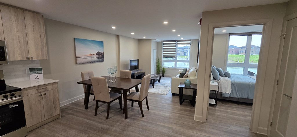 A well-lit, spacious apartment with a kitchen, dining area, and a bedroom with a balcony.