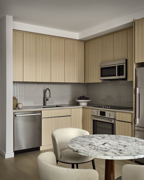 A modern kitchen with a marble table and a dishwasher.