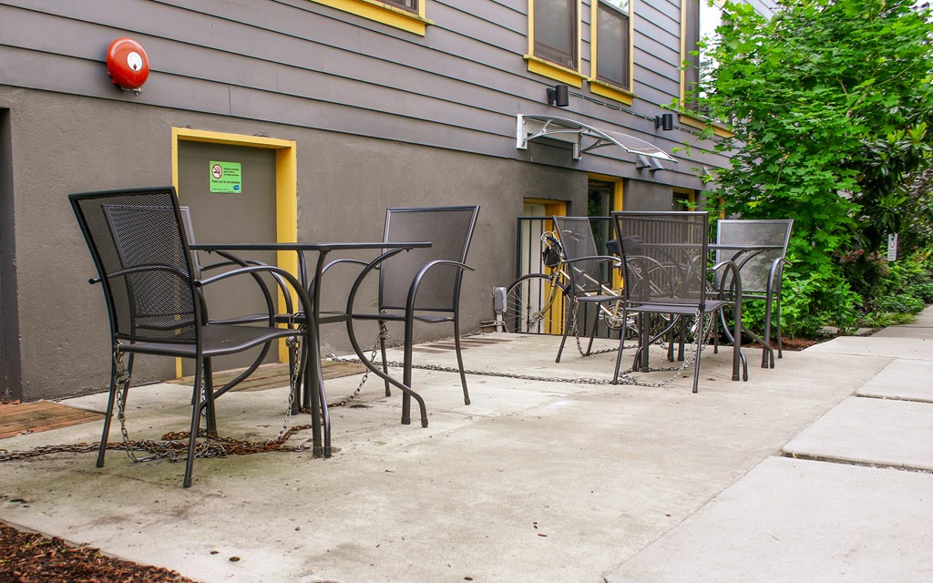 a patio with tables and chairs outside of a building