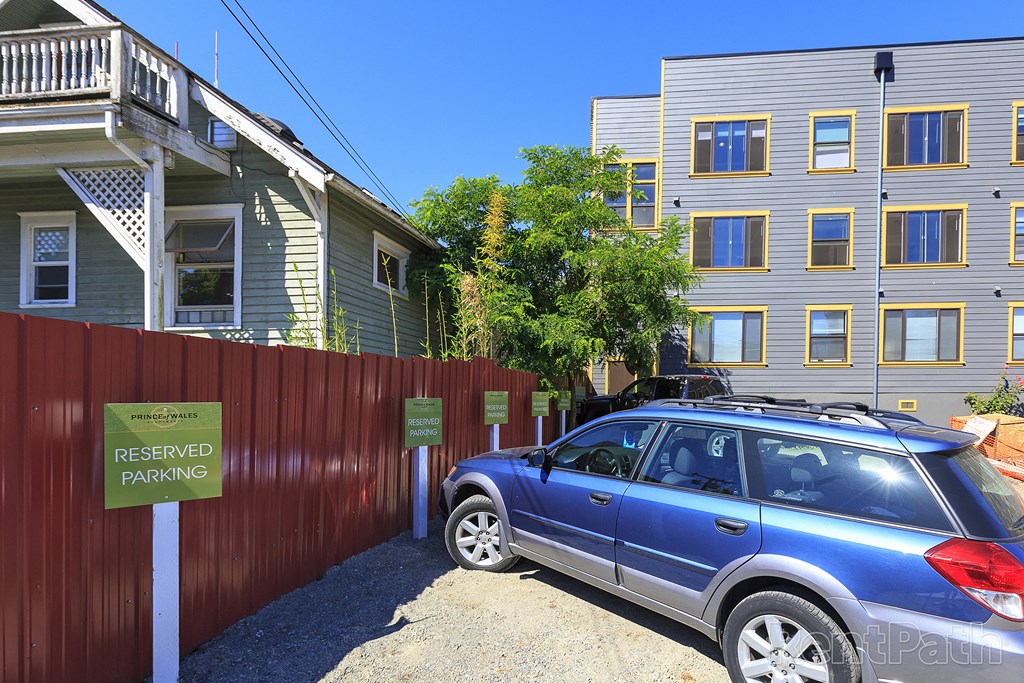 a car parked in front of a fence with a sign that reads reserved parking