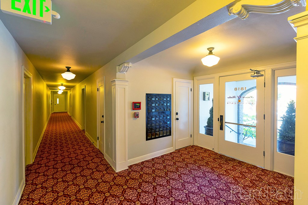 a corridor with yellow walls and red carpet