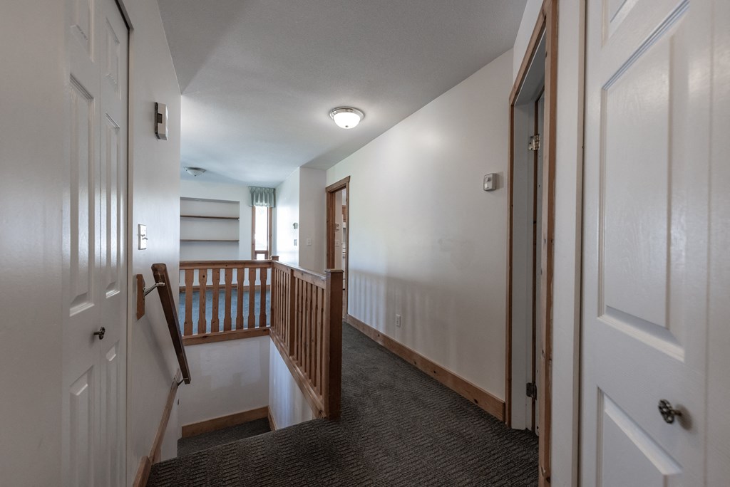 a view of the hallway from the top of the stairs