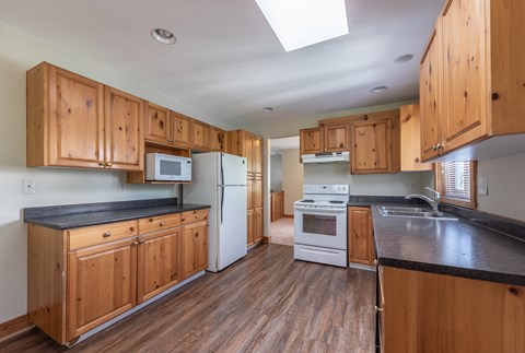 A kitchen with wooden cabinets and a black countertop.