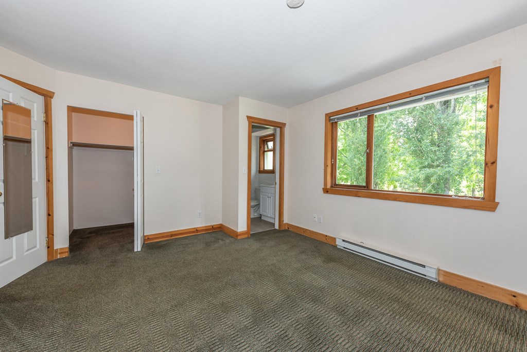 an empty room with carpet and a large window