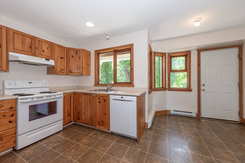 a kitchen with white appliances and wooden cabinets