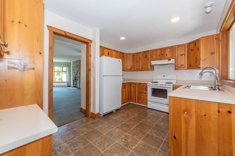 A kitchen with wooden cabinets and a white refrigerator.