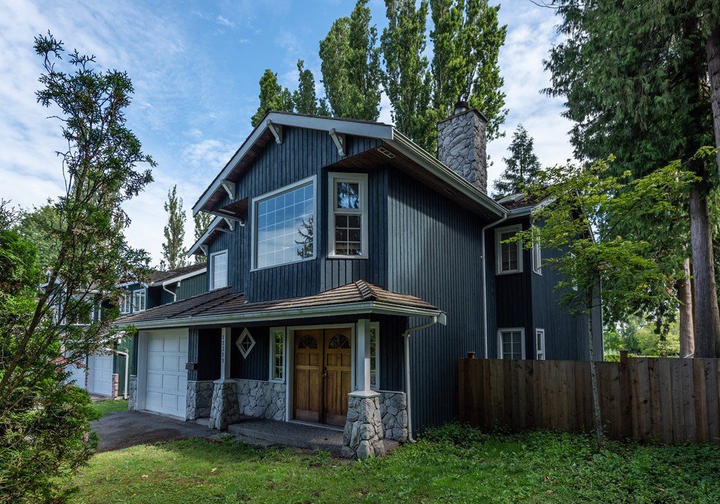 a home with a black exterior and a brown front door