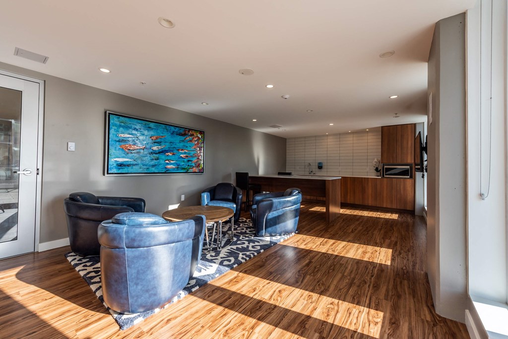 a living room with leather furniture and a kitchen