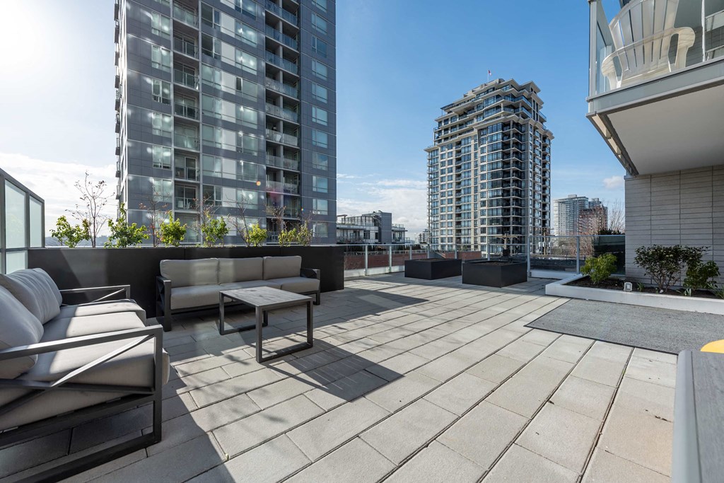 a roof top patio with furniture and a view of the city