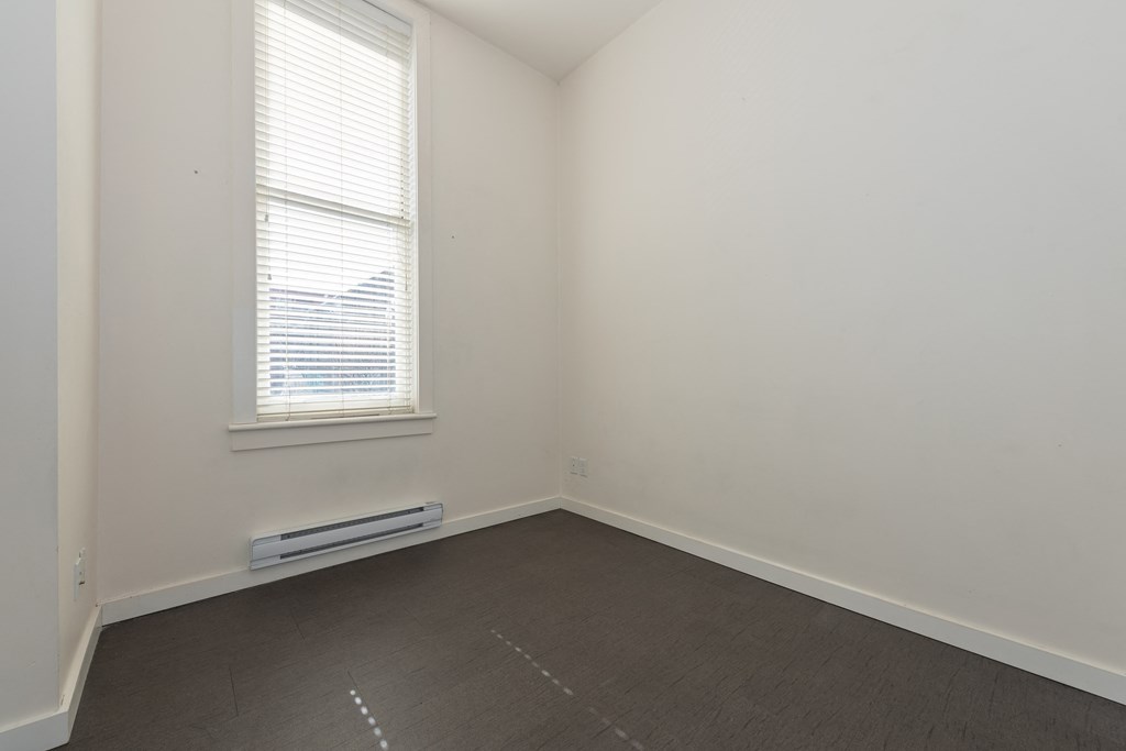 an empty room with white walls and a window