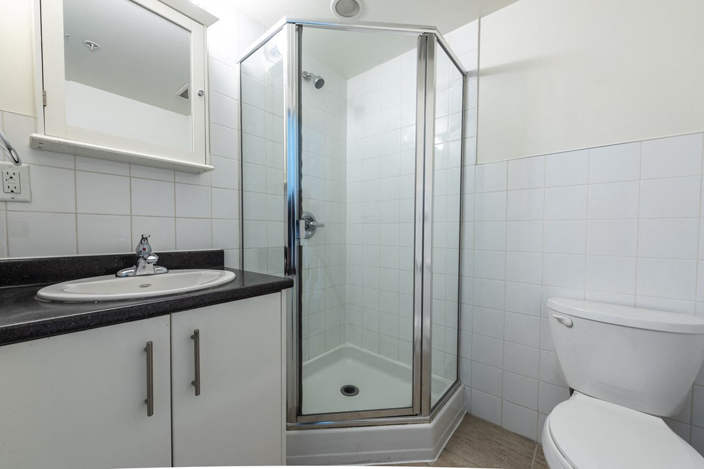 a bathroom with a shower and a sink and a toilet