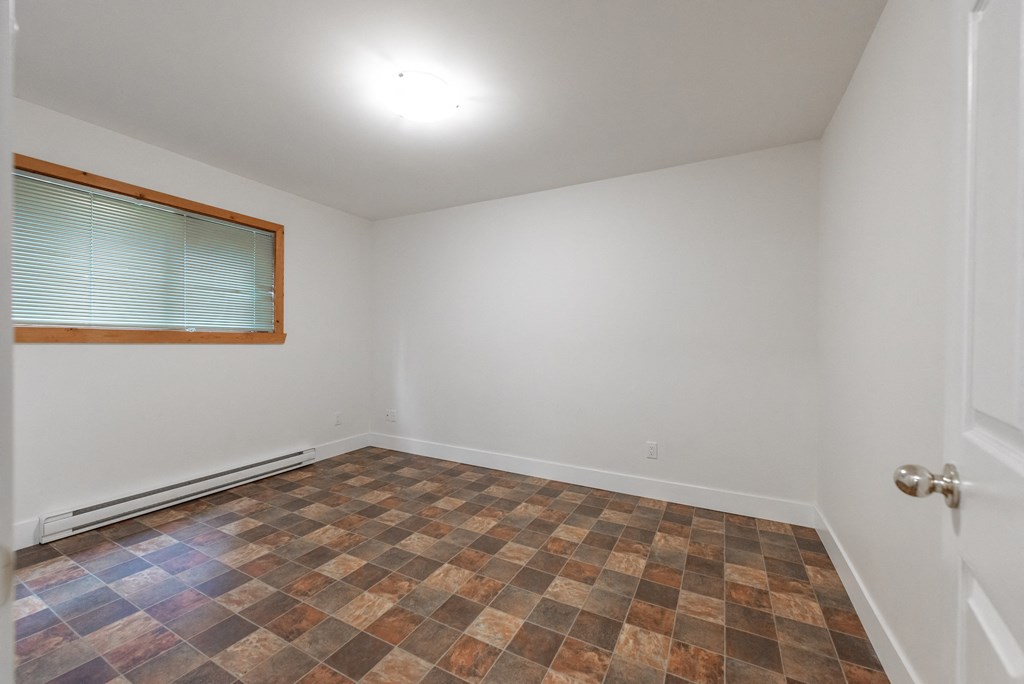 an empty room with a window and a door