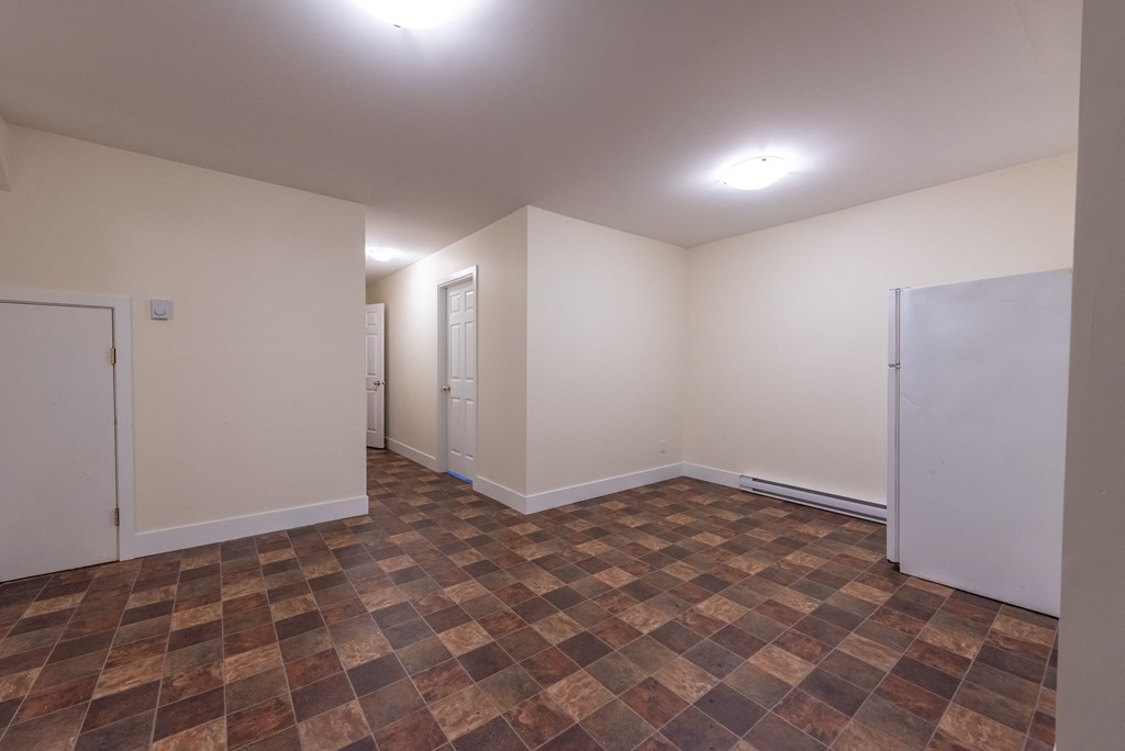 a bedroom with white walls and a tiled floor