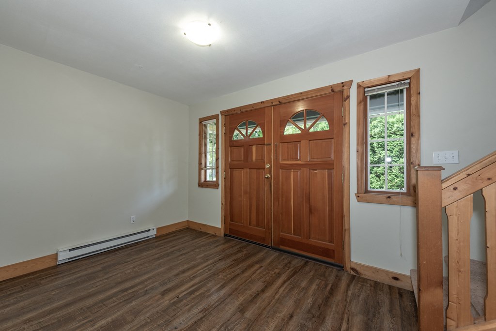 an empty room with wooden floors and a wooden door