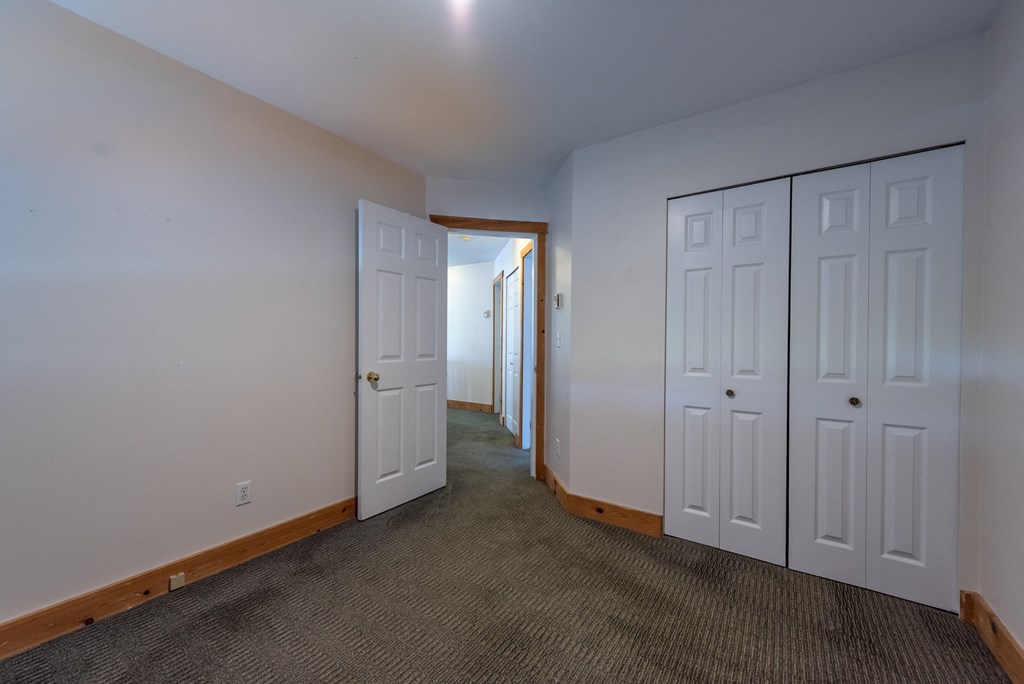a bedroom with two doors and a carpeted floor