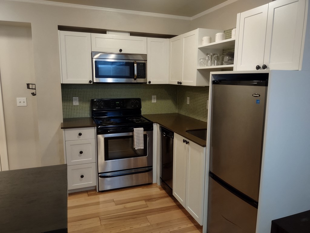a kitchen with white cabinets and stainless steel appliances