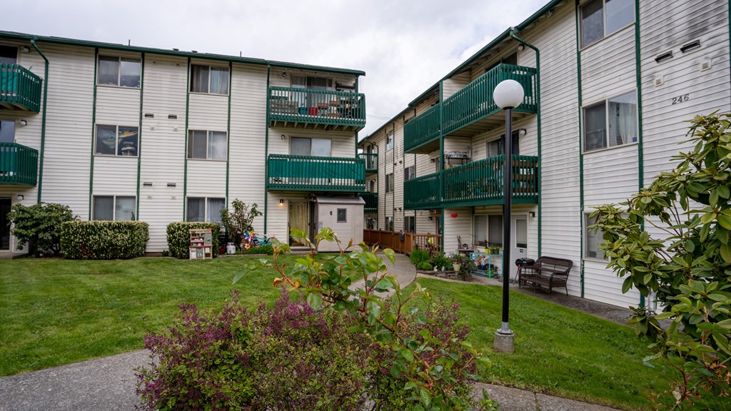 a picture of two apartment buildings with green and white railings